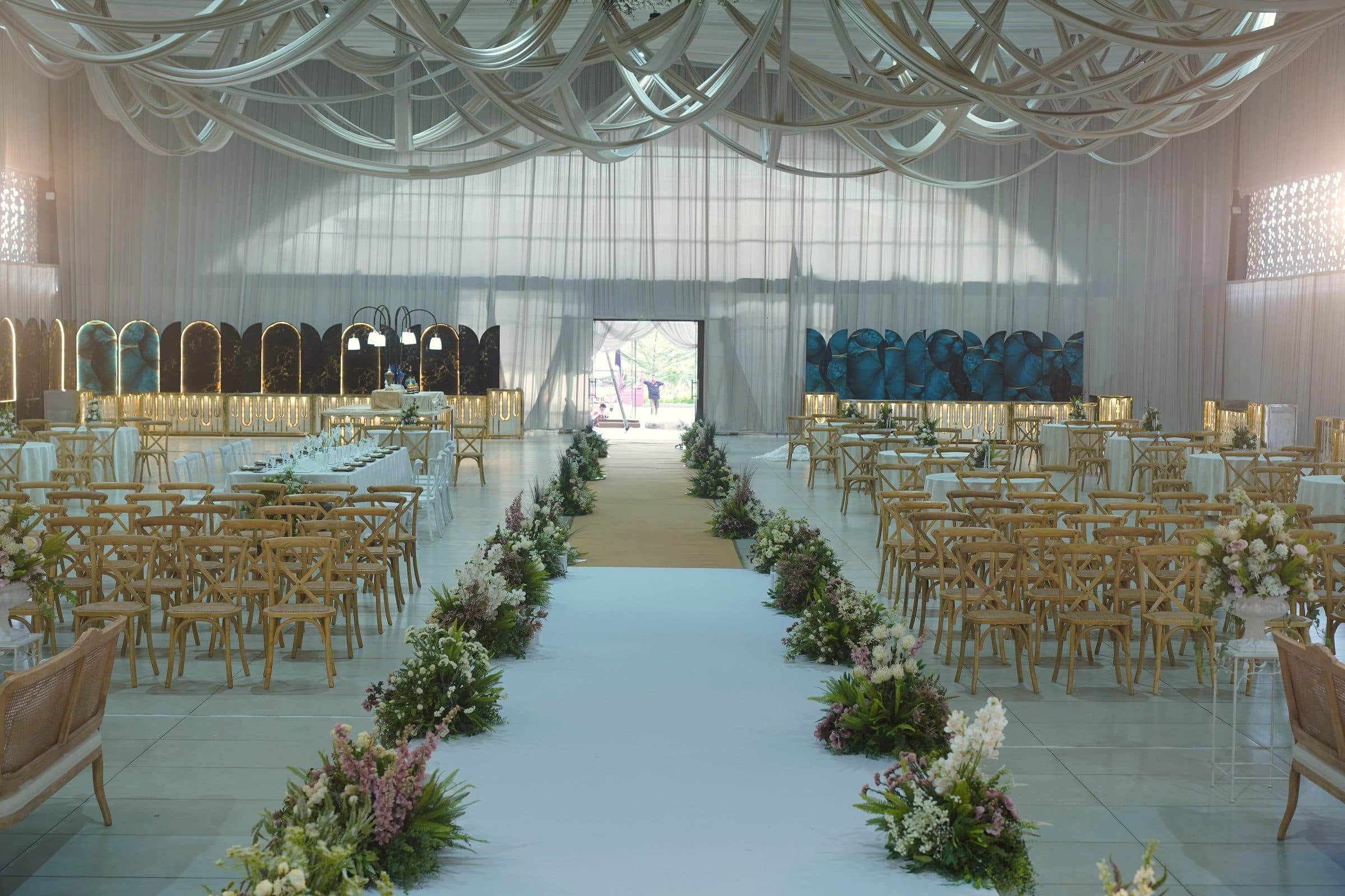 The ceremony aisle framed by guest seating, open doors beyond