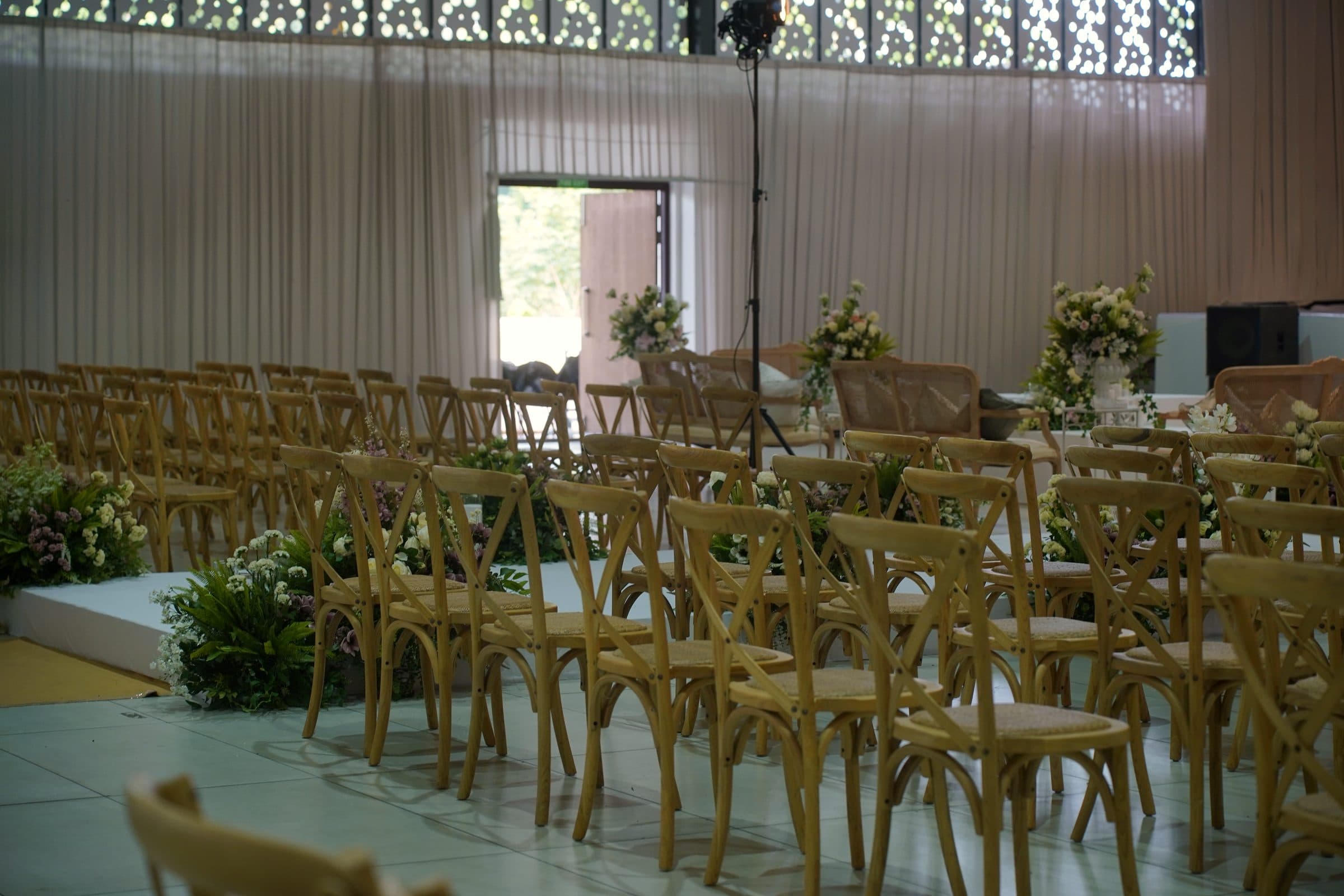 Cross-back chairs arranged for a ceremony beside the aisle