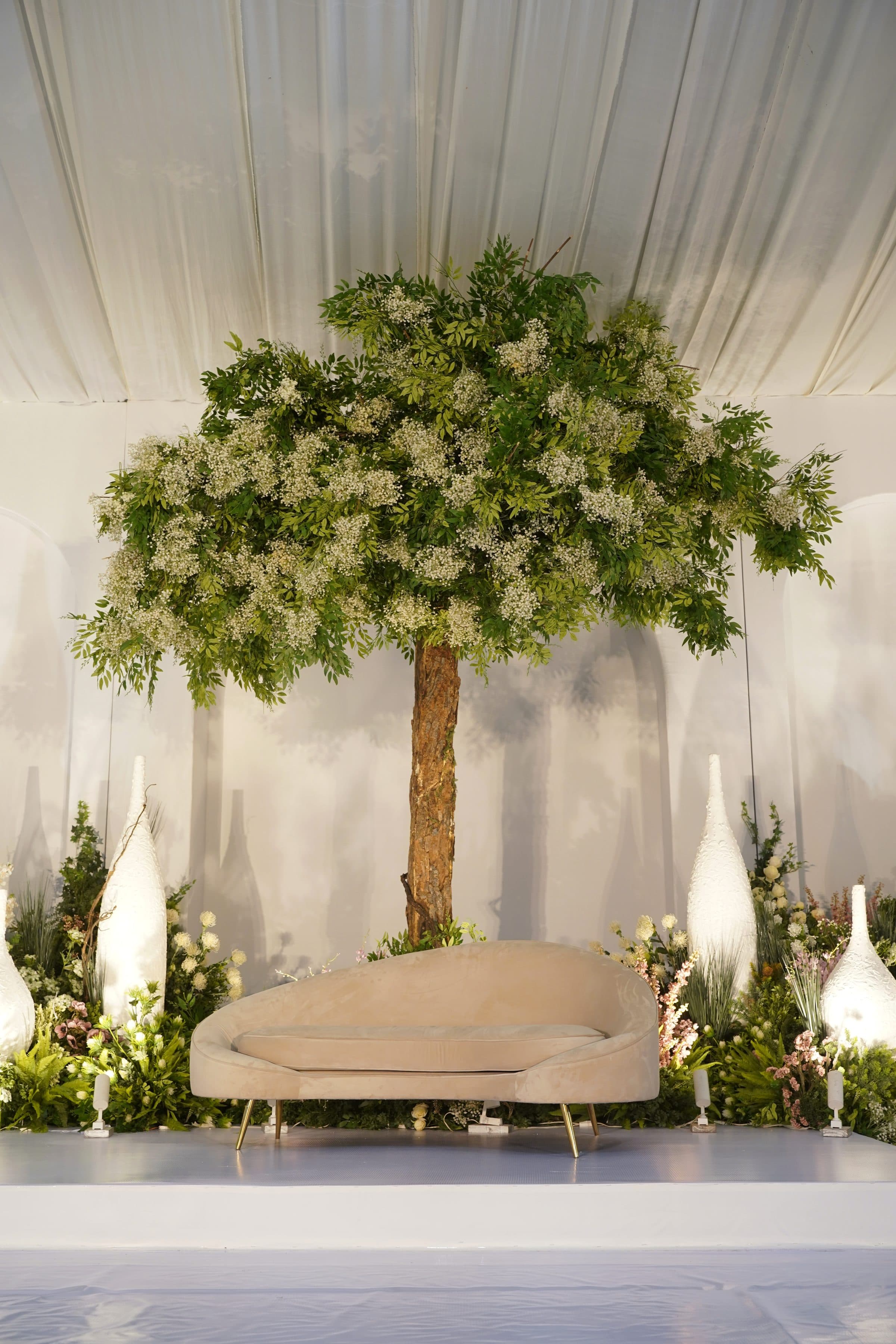 A tall ceremonial arch banked with white flowers