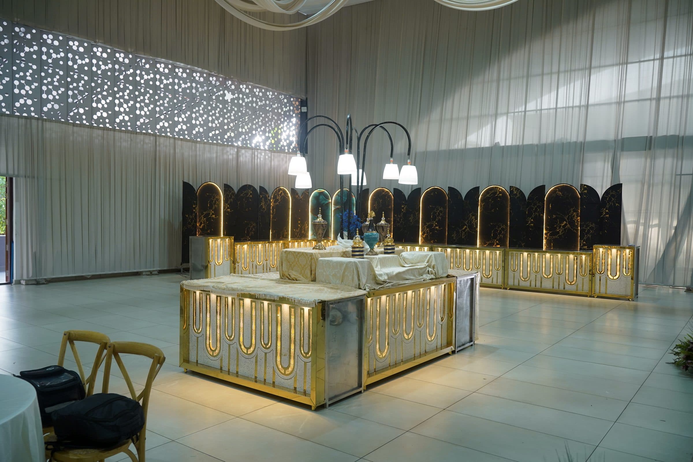 A gold-framed display counter beneath a chandelier