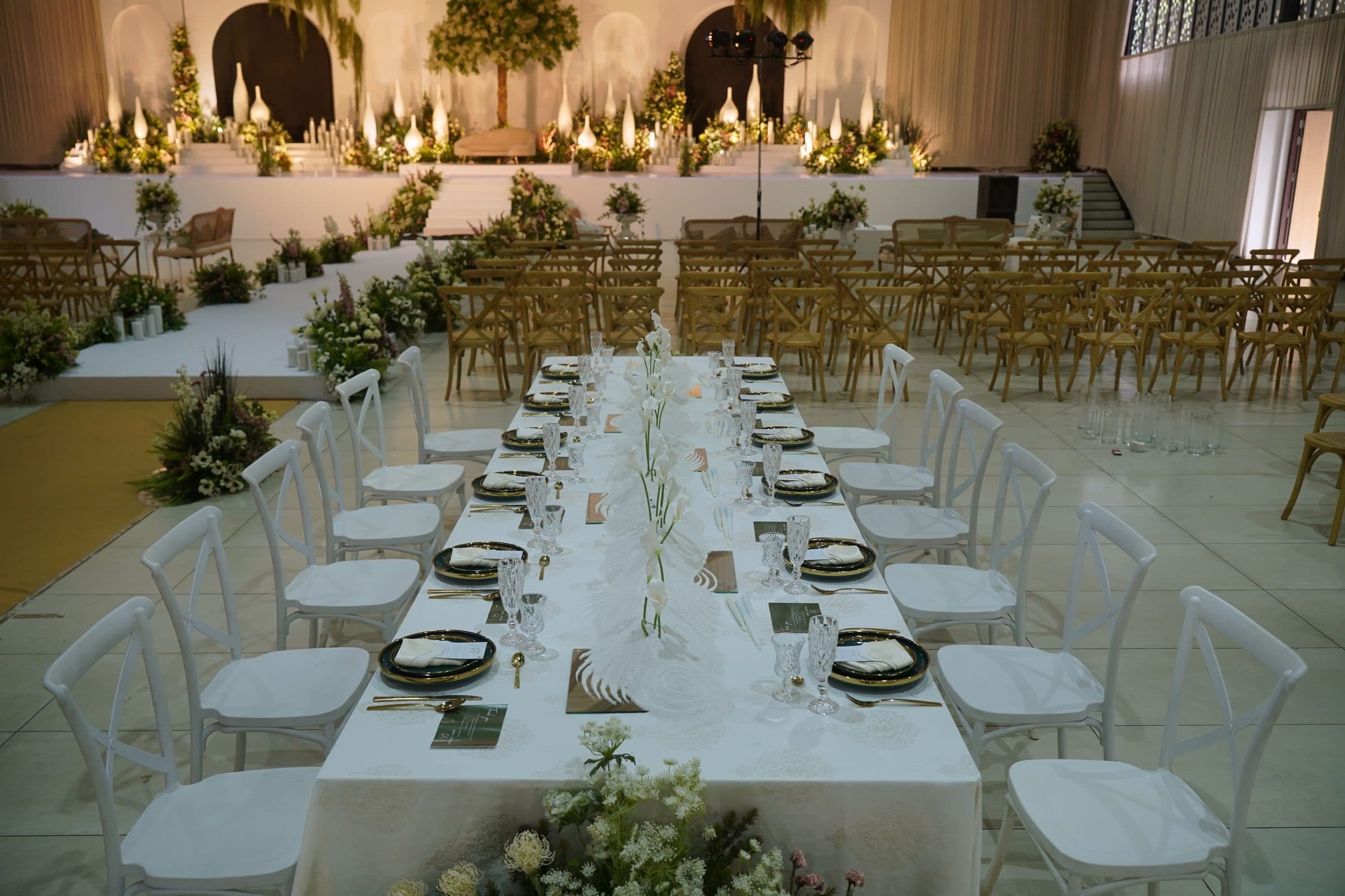 Long banquet tables set with black and gold place settings