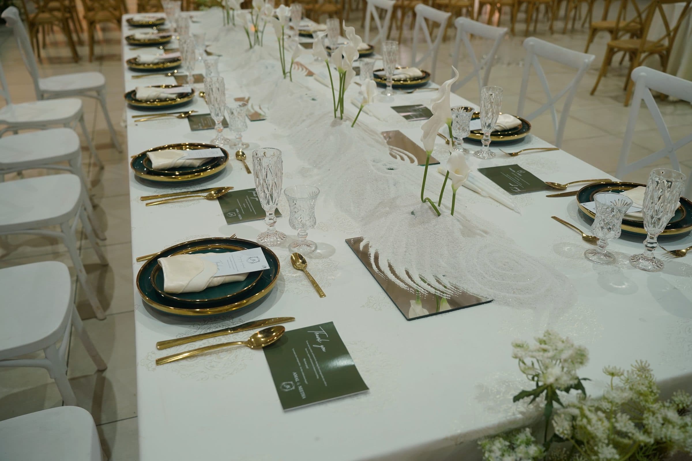 A single place setting — gold cutlery, cut glass and a pressed menu card