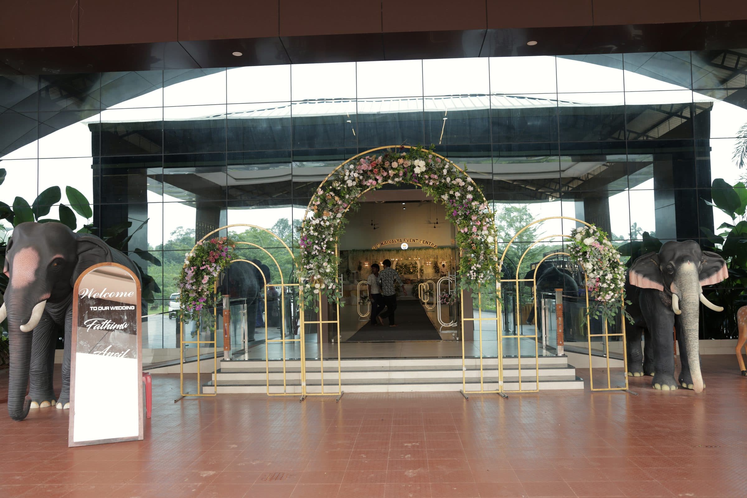 The mirrored entrance dressed with a floral archway and ceremonial elephants
