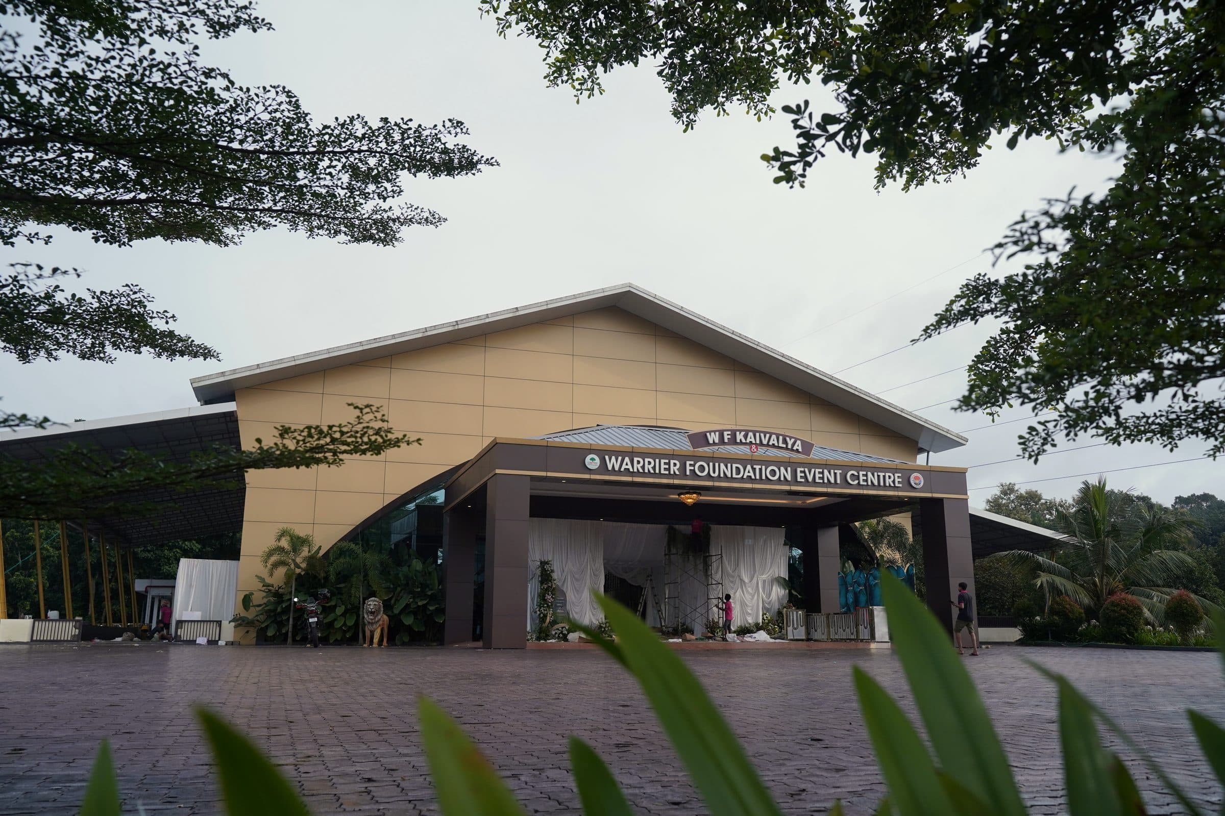 The W F Kaivalya entrance and its signboard framed by trees at dusk