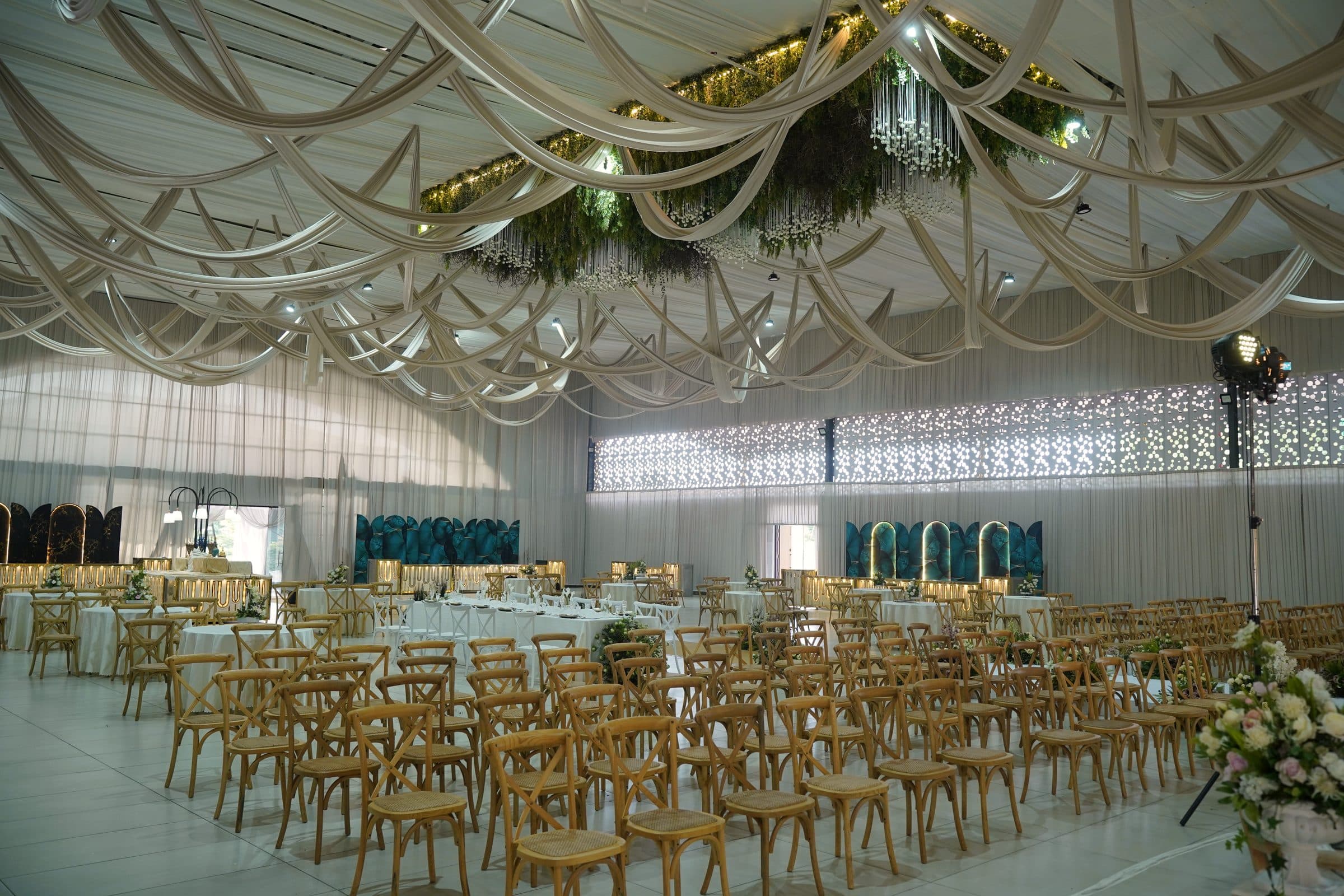 The hall laid with rows of cross-back chairs beneath the draped ceiling