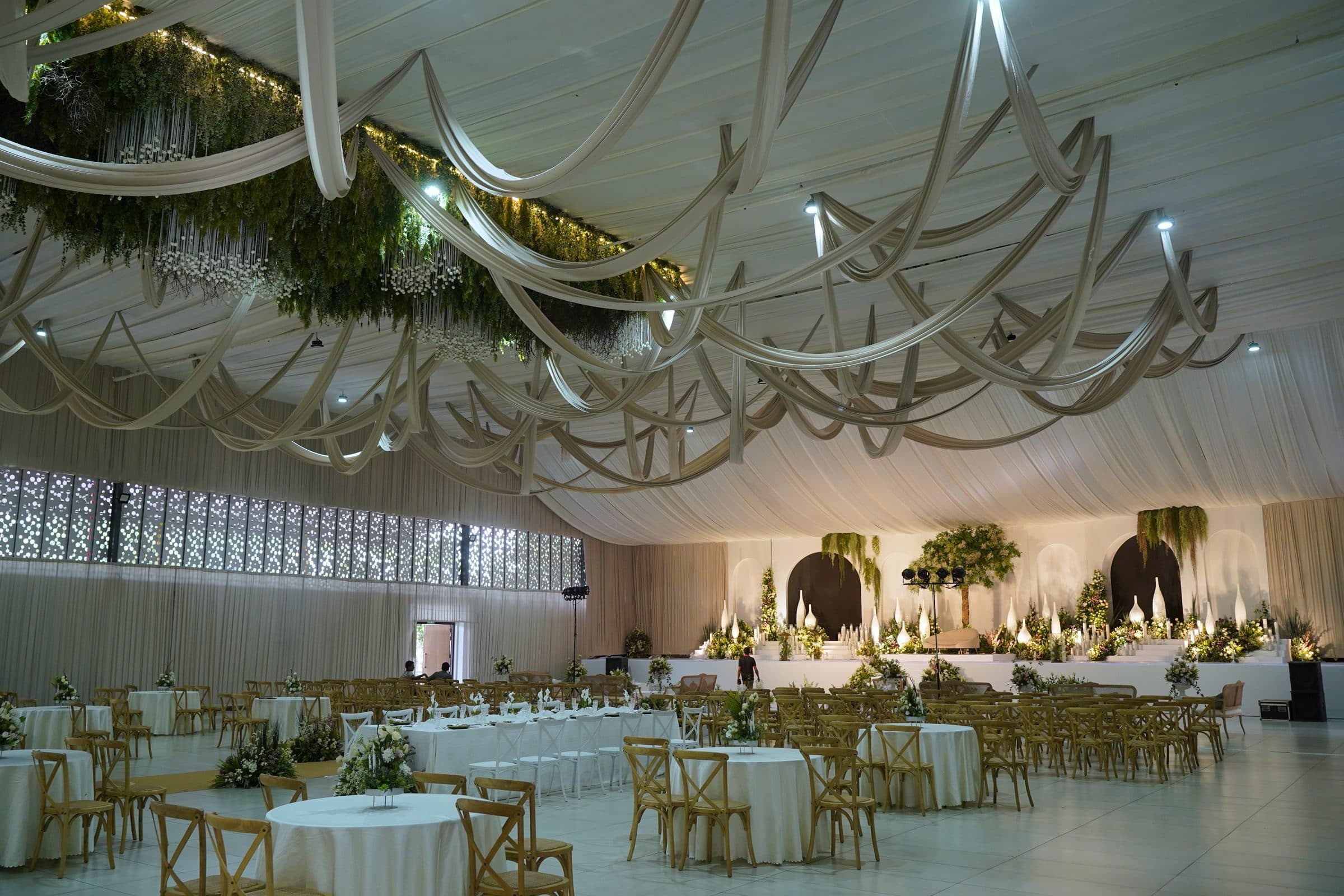 The draped ceiling sweeping above round banquet tables