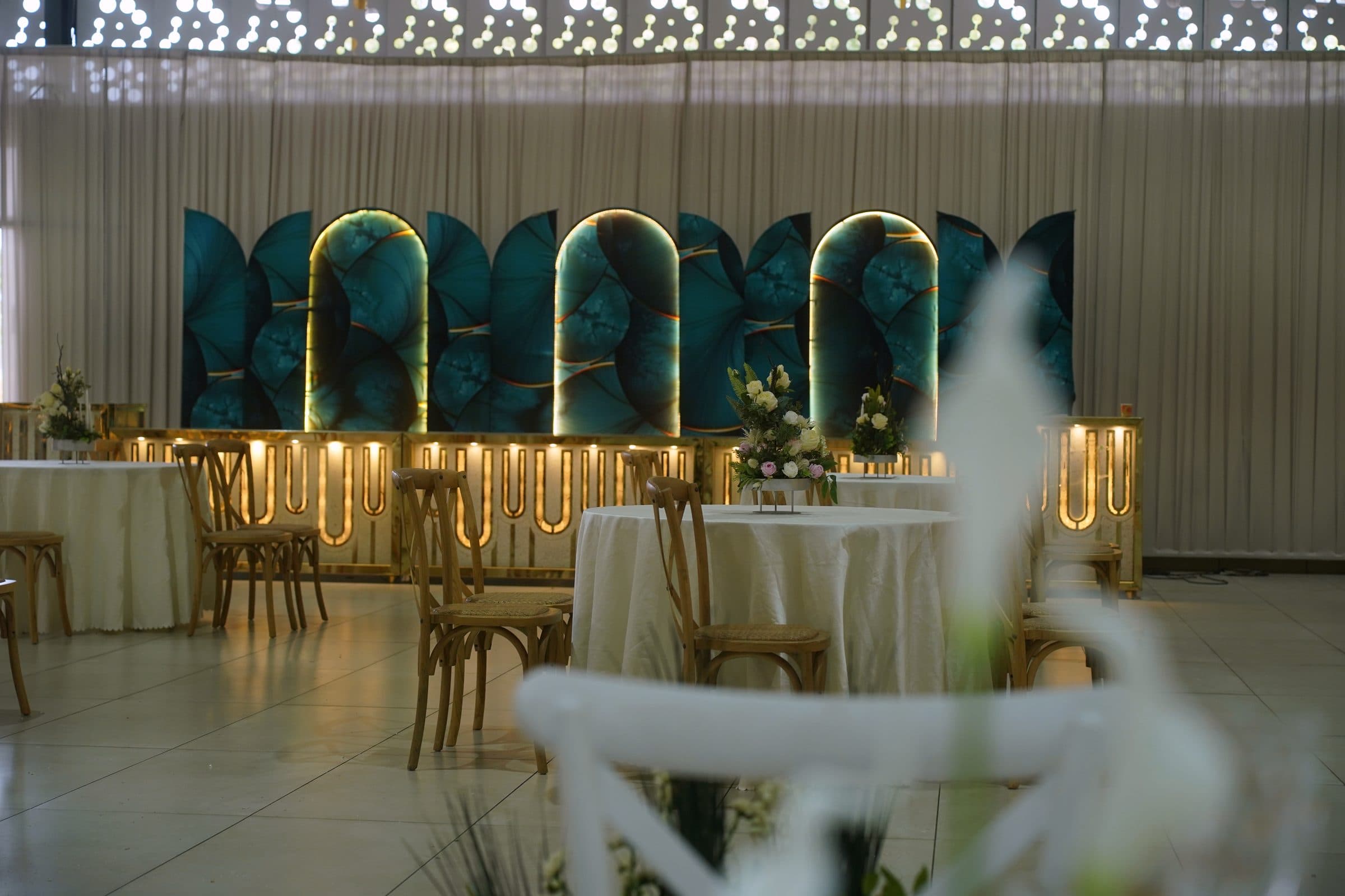 The teal and gold reception backdrop with dressed tables