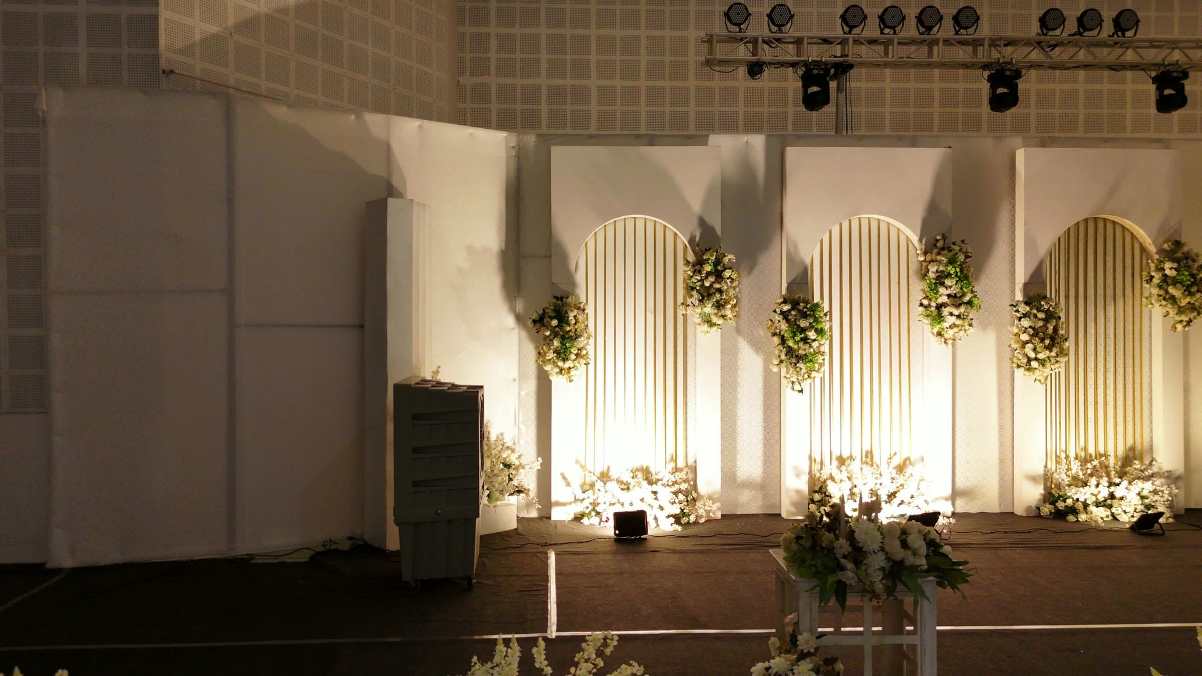 The fluted stage backdrop lit warm for an evening reception